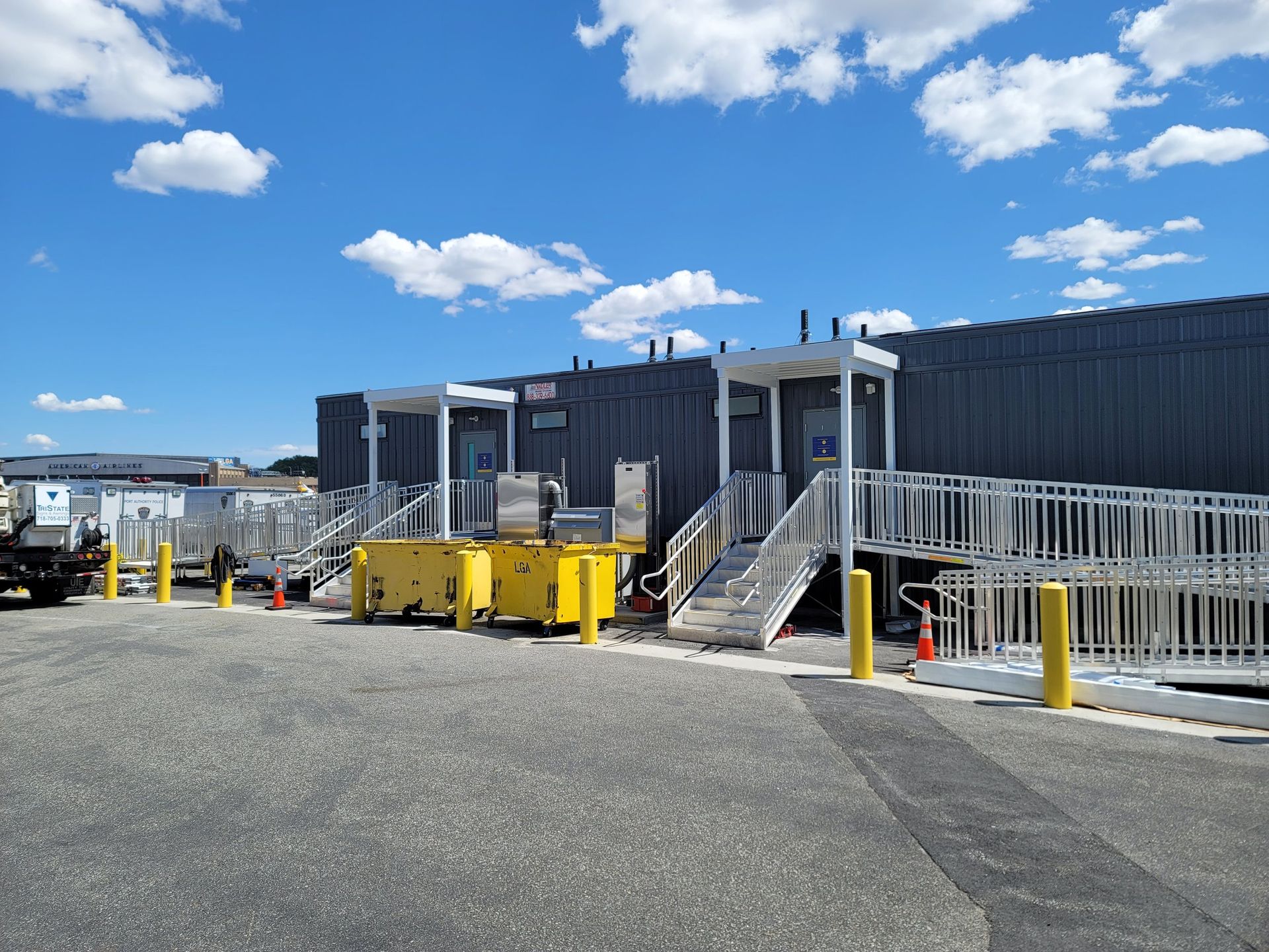 A row of buildings with stairs leading up to them in a parking lot.
