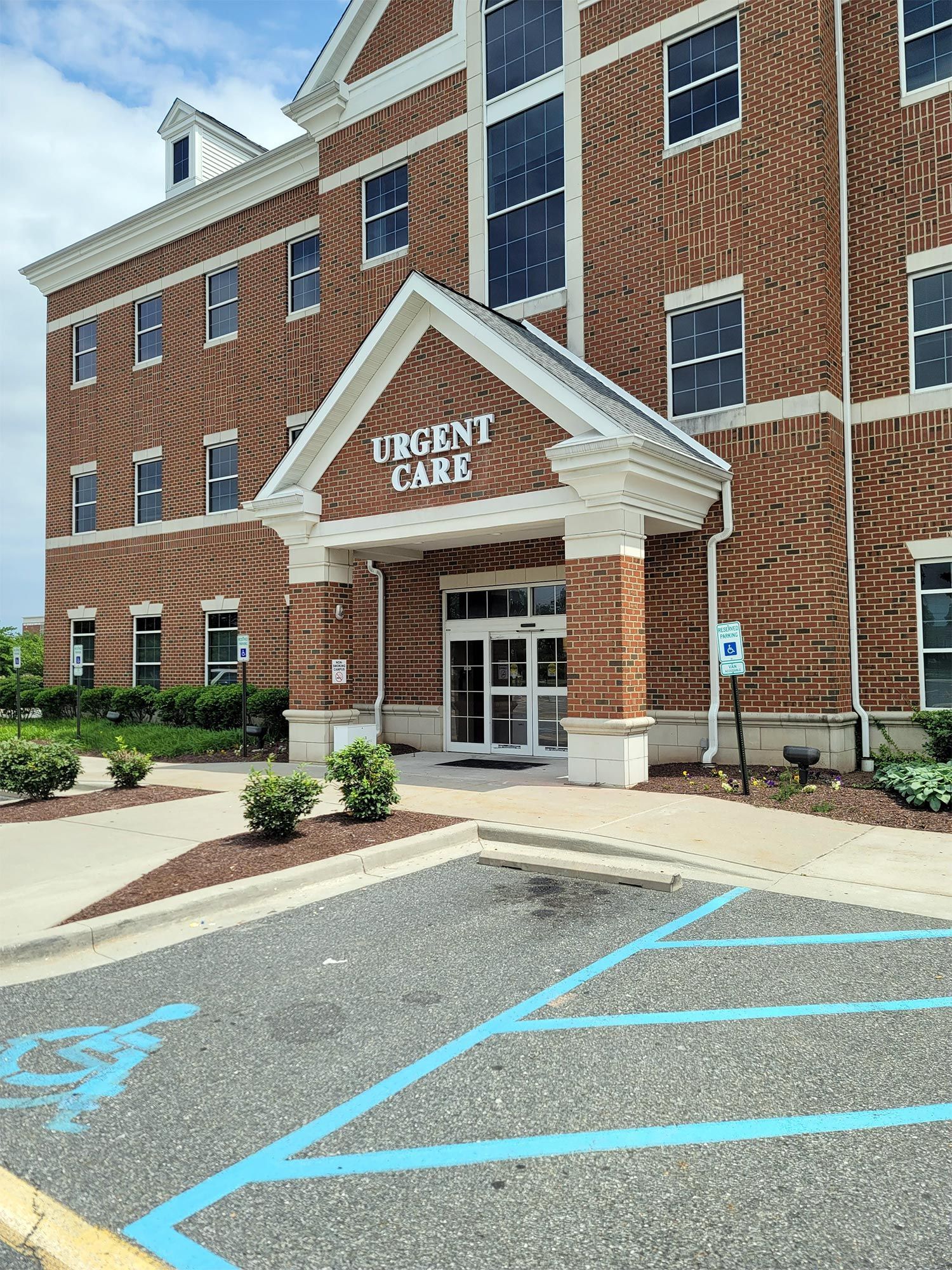 A large brick building with a handicapped parking spot in front of it.
