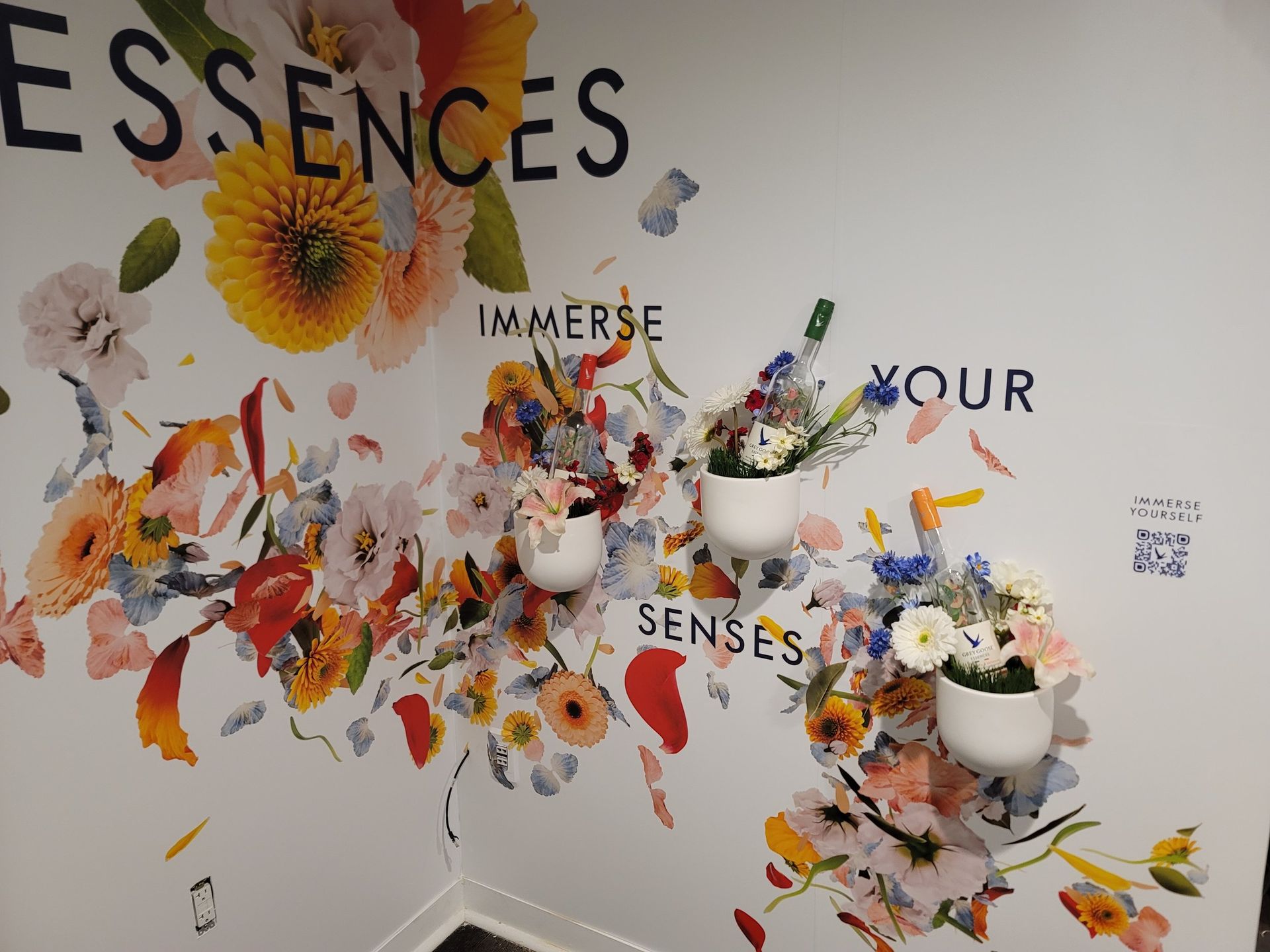 A wall with flowers and the words essences on it