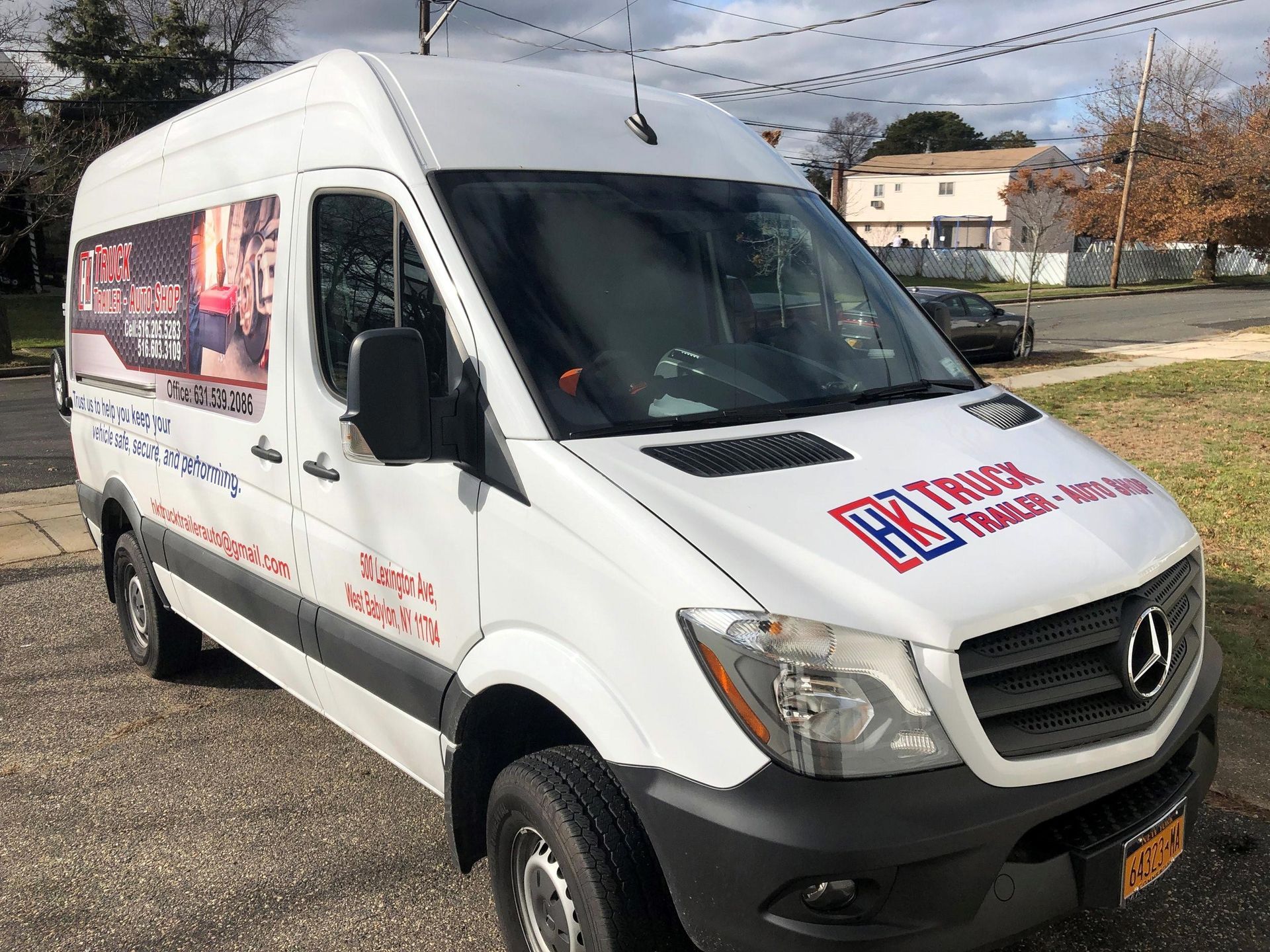 A white van is parked on the side of the road.