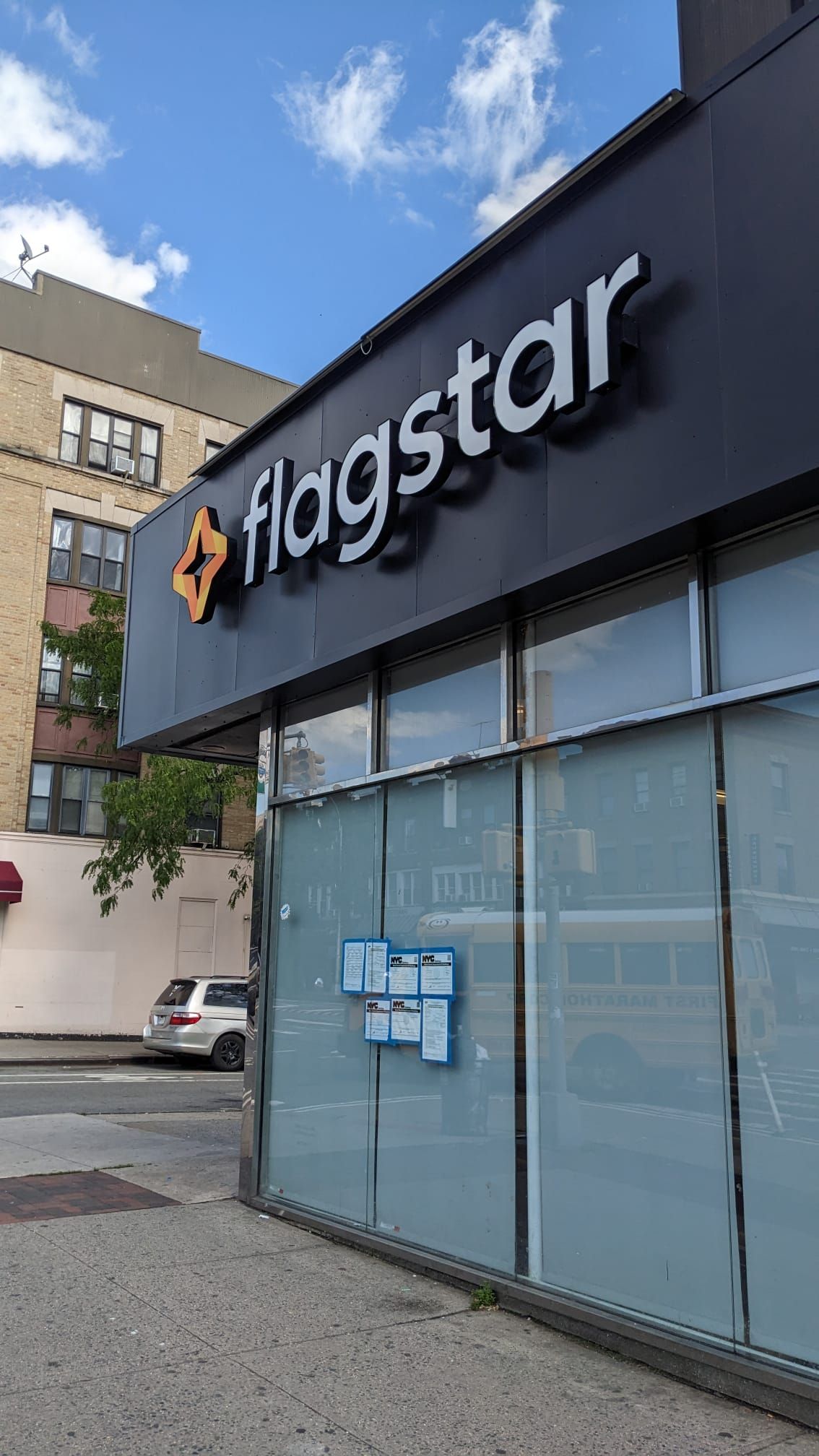 A flagstar store is located on the corner of a city street.