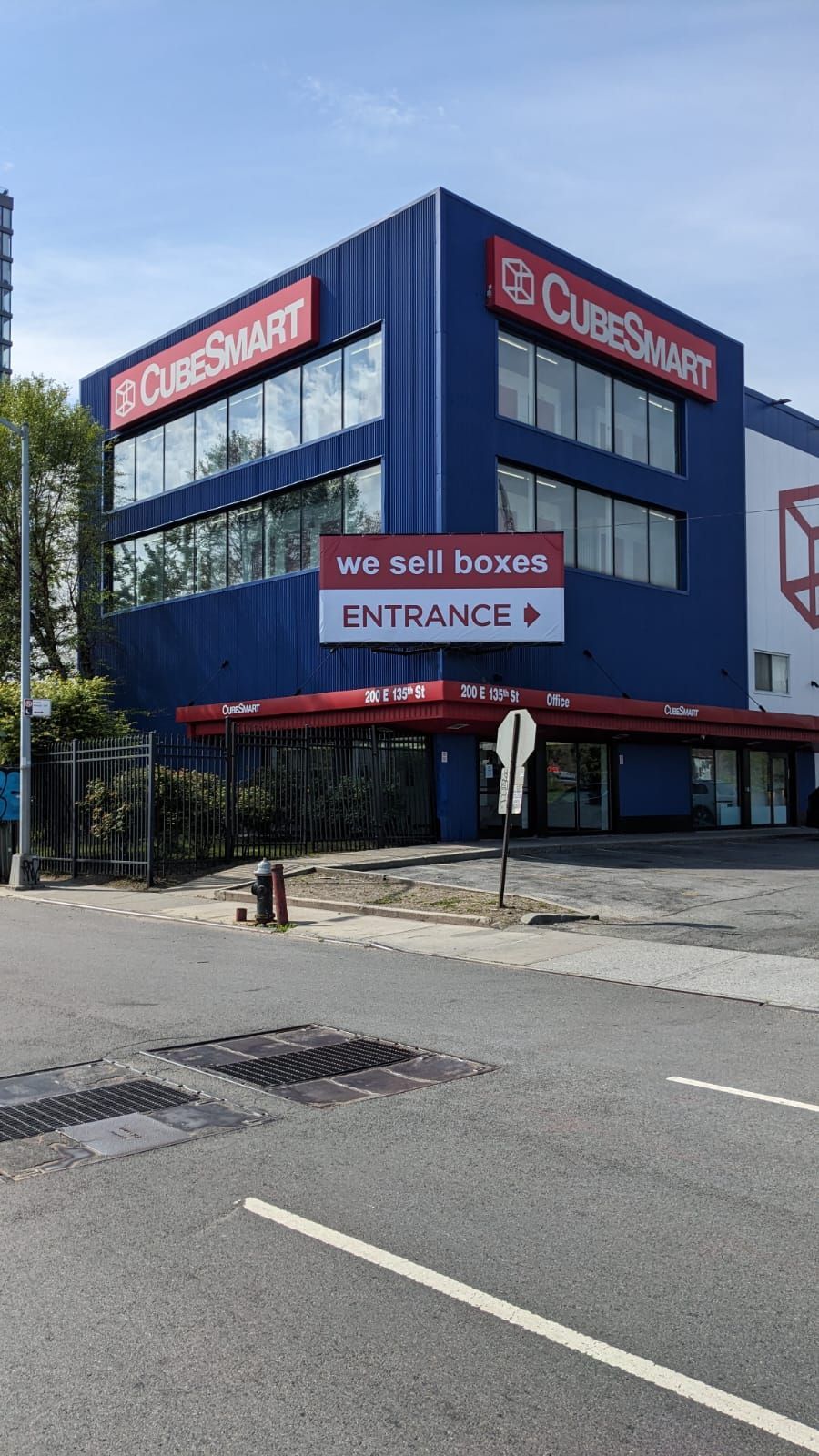 A large blue building with a red sign that says `` we sell boxes entrance ''.