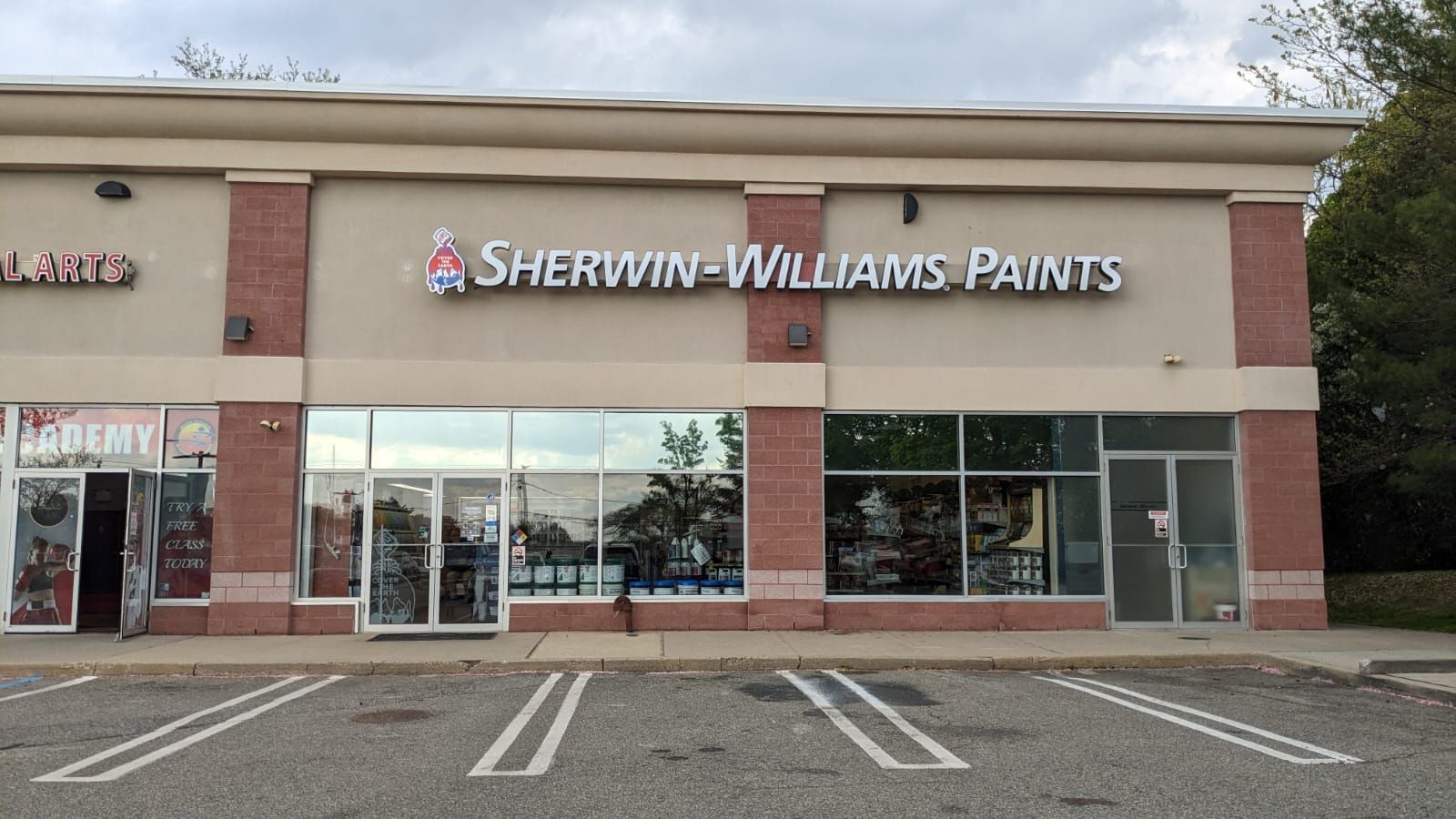 A sherwin williams paints store with a parking lot in front of it