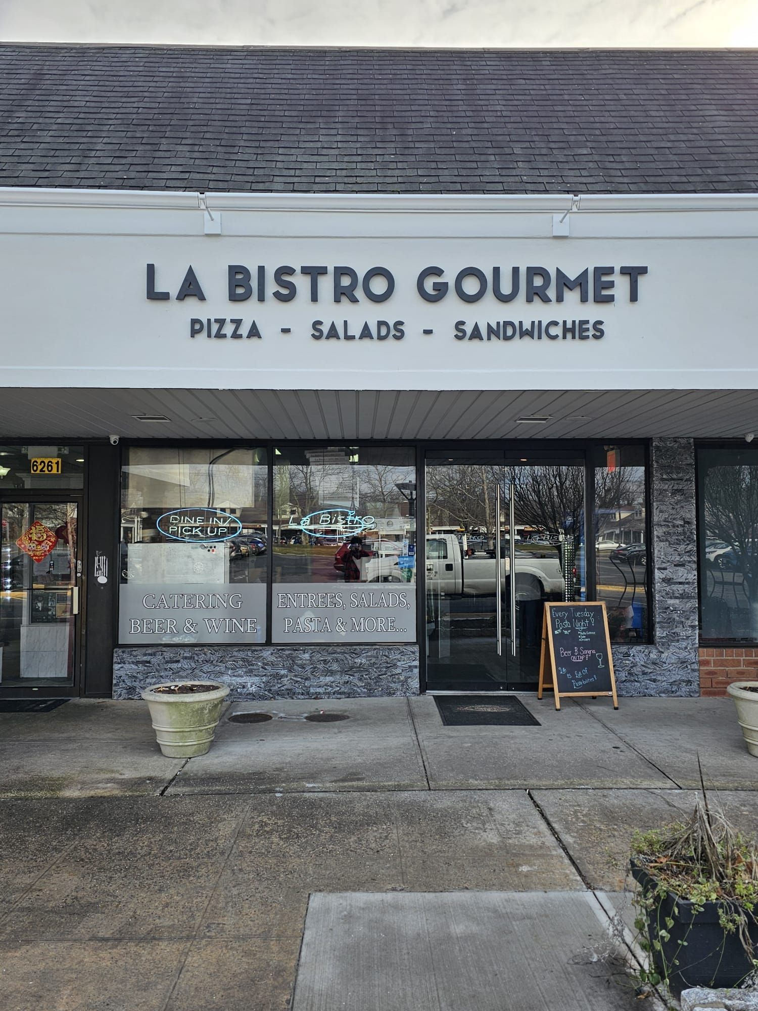 The front of a restaurant called la bistro gourmet pizza salads and sandwiches.