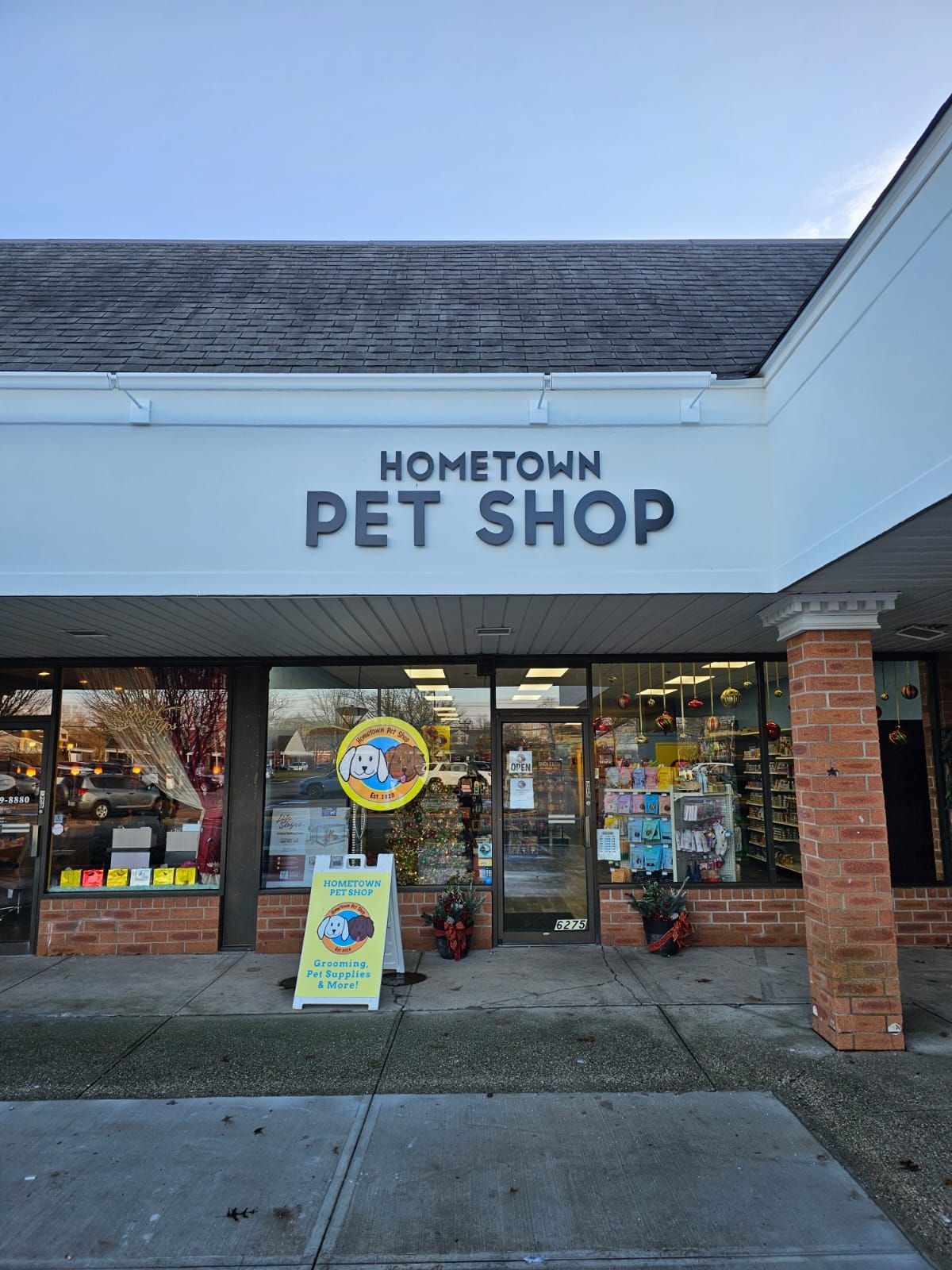 The front of a hometown pet shop with a sign in front of it