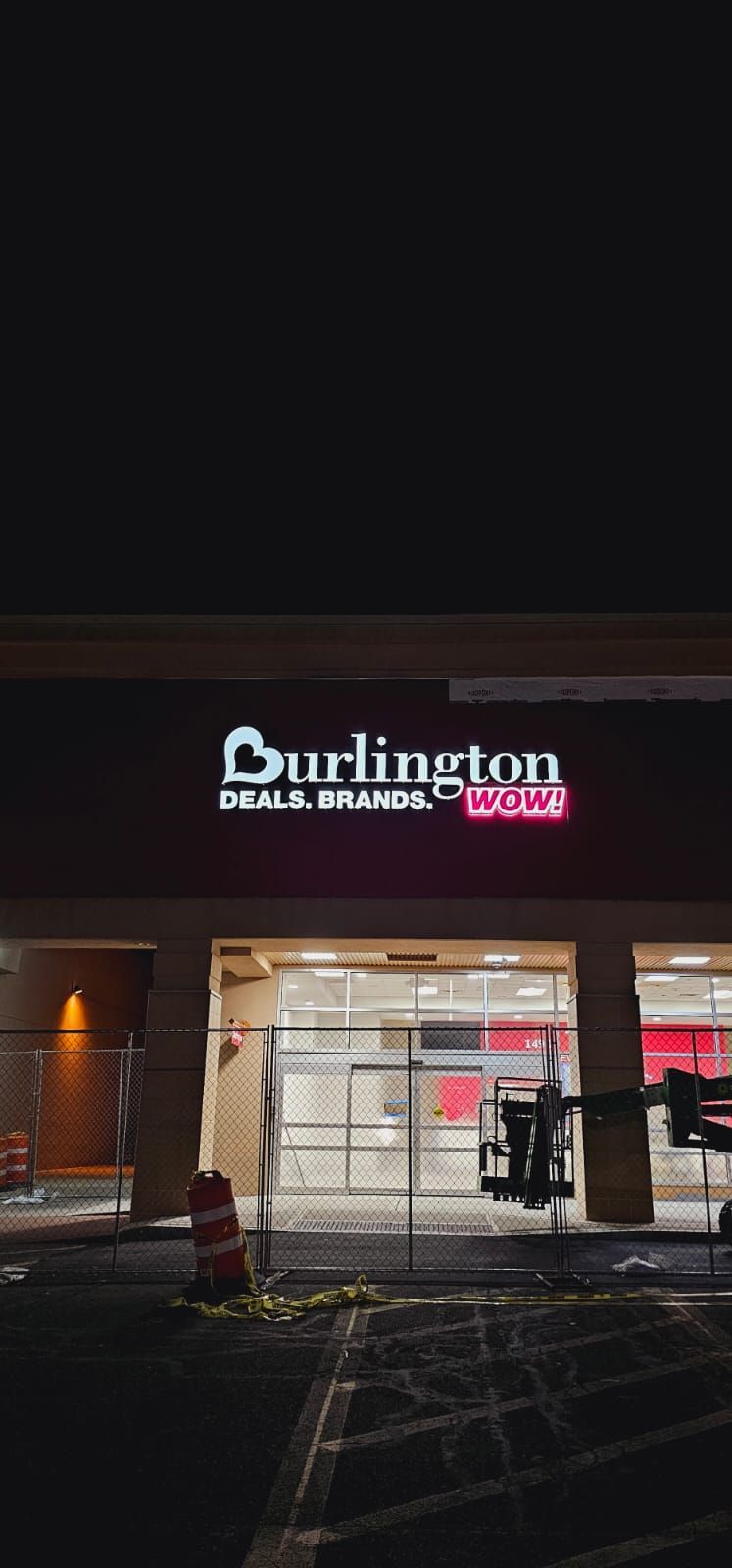 The front of a burlington store is lit up at night.