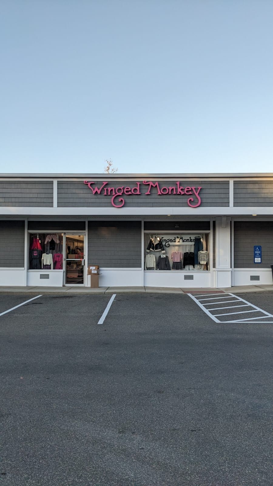 A store front with a parking lot in front of it.