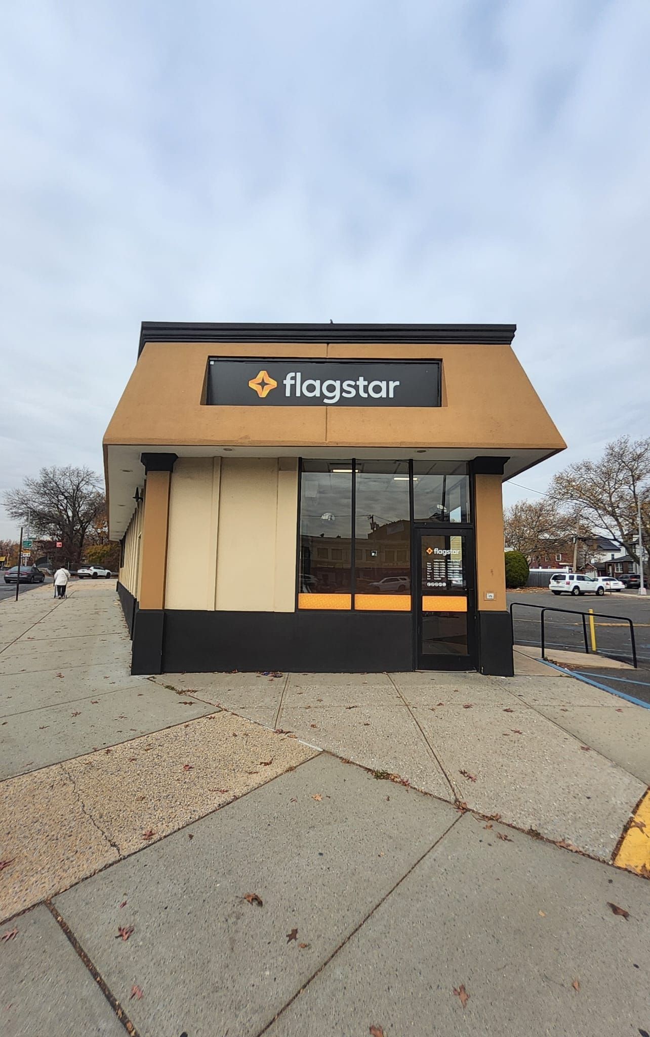 A small brown and black building with a sign on top of it.