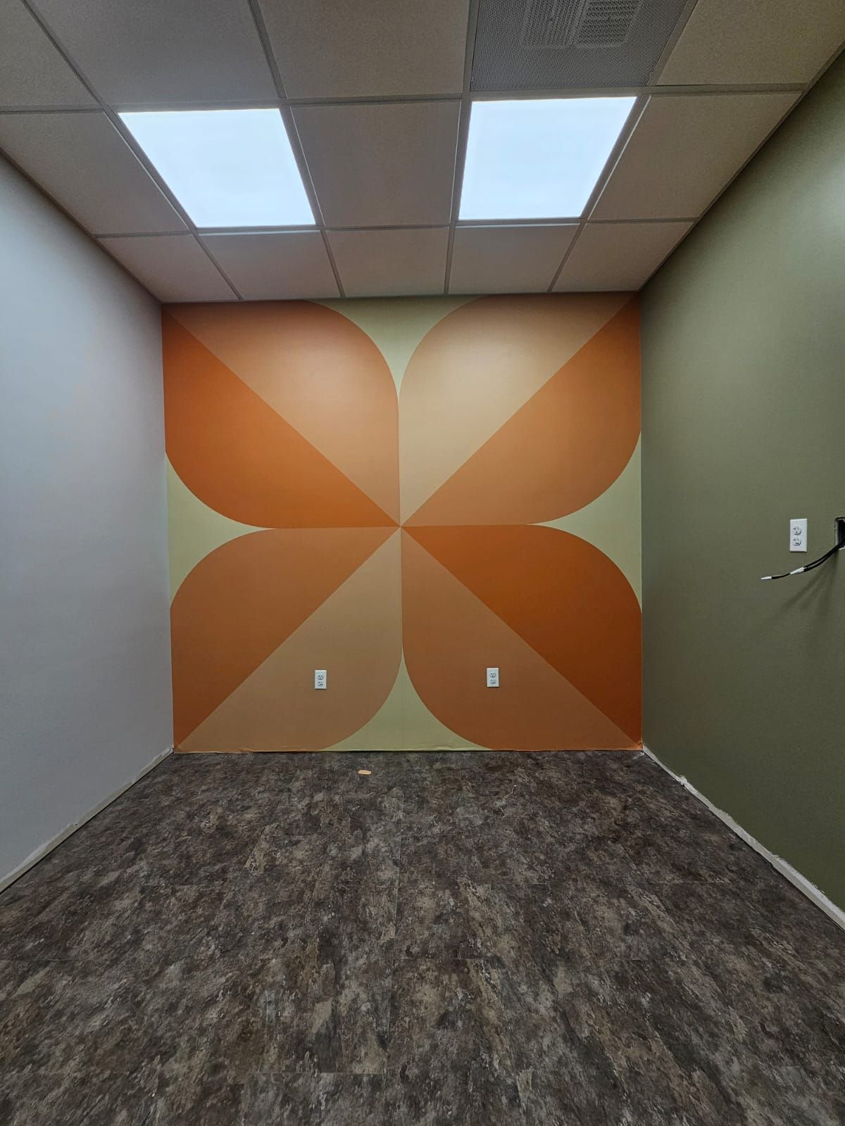 An empty room with a geometric design on the wall.