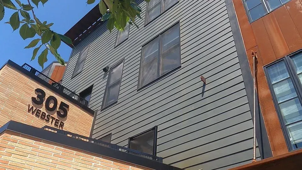 Building exterior with gray siding, brick, and 
