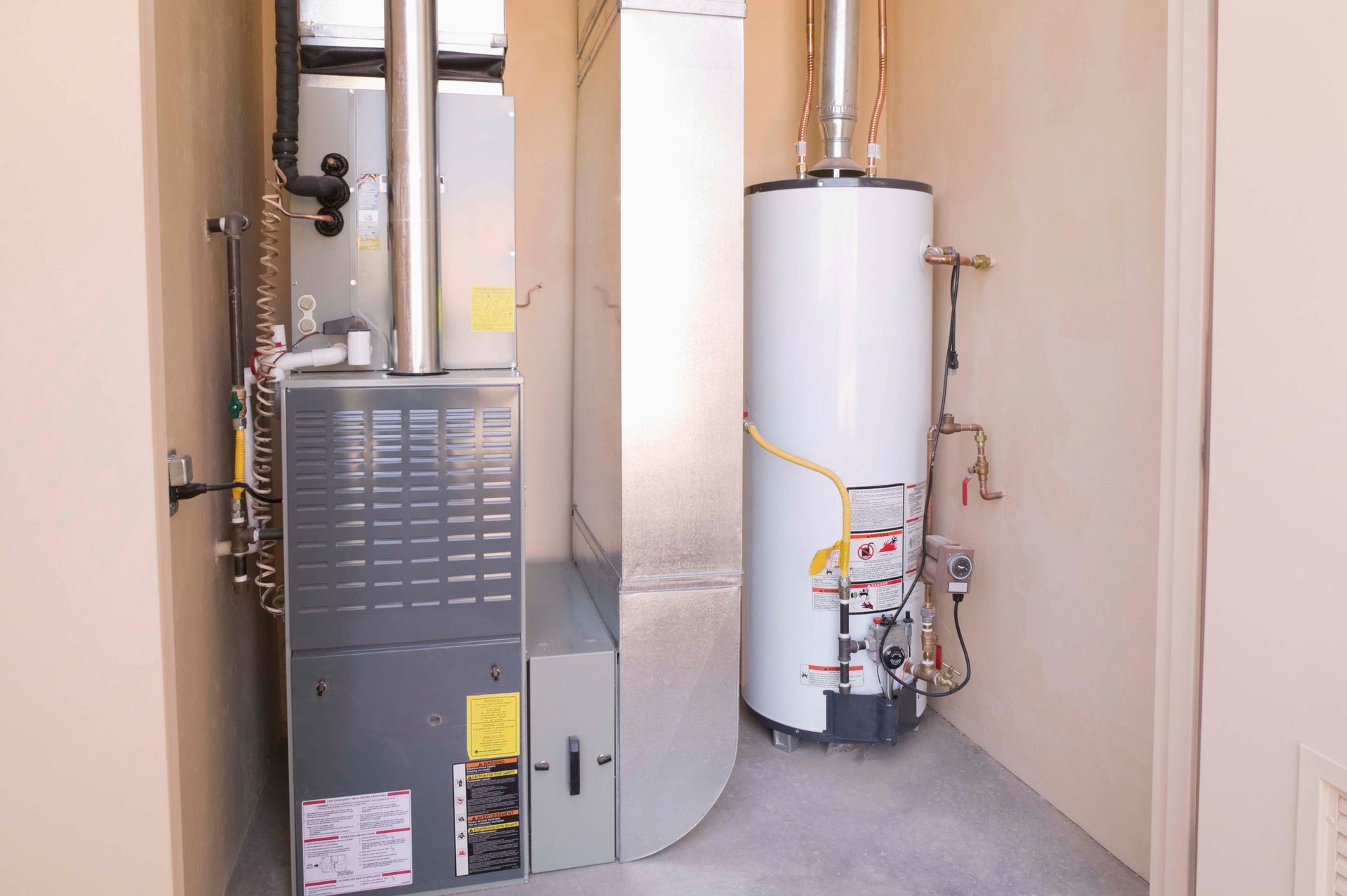 Furnace and water heater in a utility closet with a large metal vent.