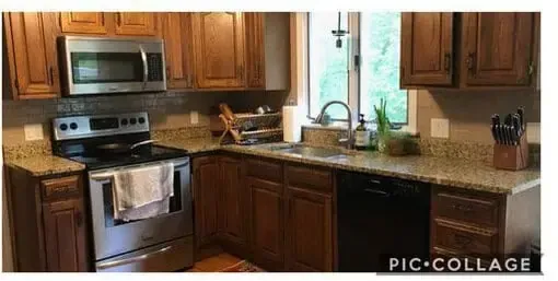 Modern kitchen with wooden cabinets, stainless steel appliances, granite counters, and a window over the sink