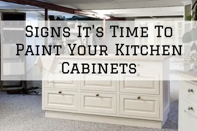 Text overlay on a kitchen with white cabinets: “Signs it’s time to paint your kitchen cabinets.”