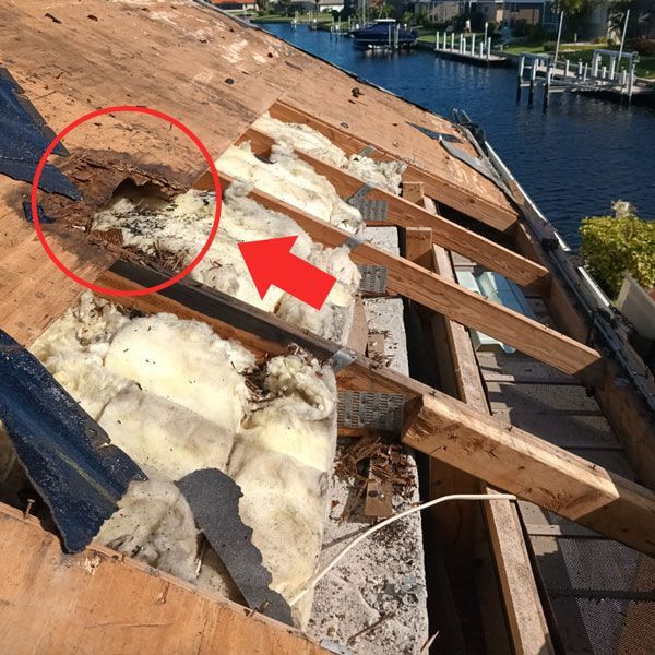 A roof with a red arrow pointing to a hole in it