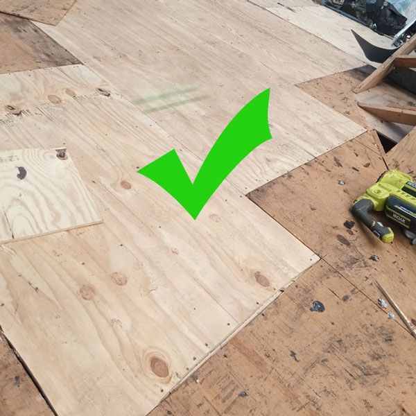 A green check mark is on a piece of wood.