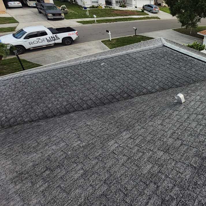 A white truck is parked on the roof of a house.