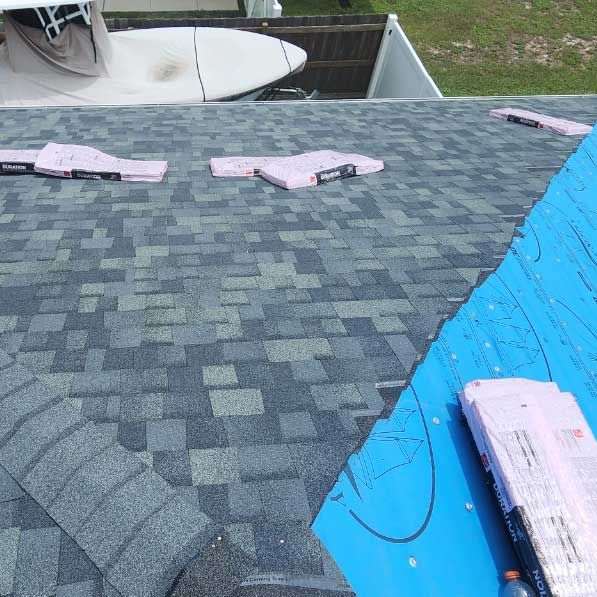 A roof with shingles being installed on it