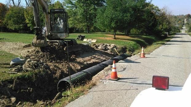a large pipe is being installed on the side of the road