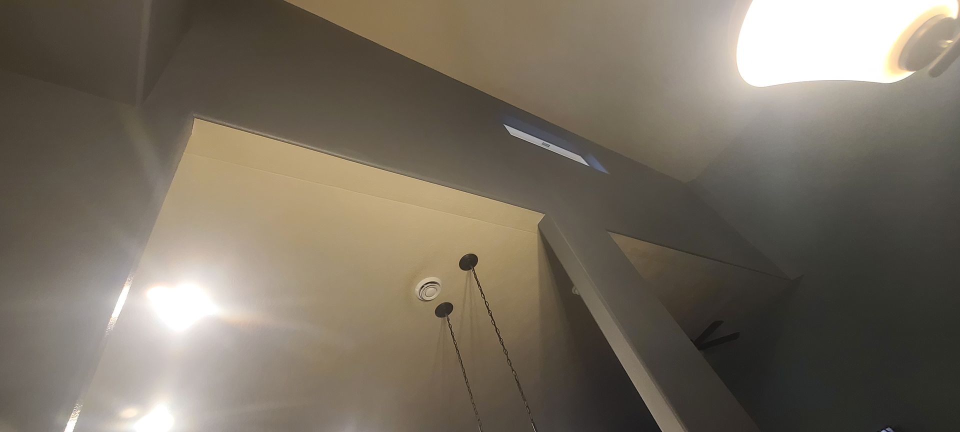 Ceiling with recessed lights, beams, and decorative trim.