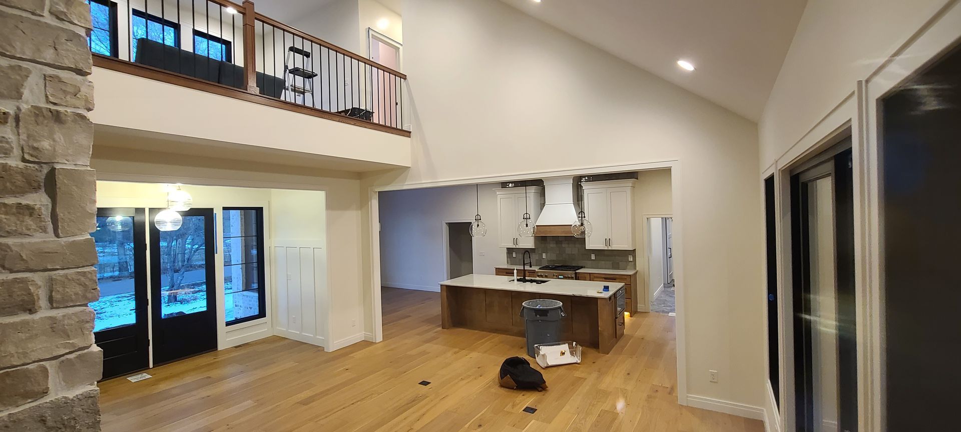 Interior of a new home with an open layout, hardwood floors, a kitchen island, and a loft.