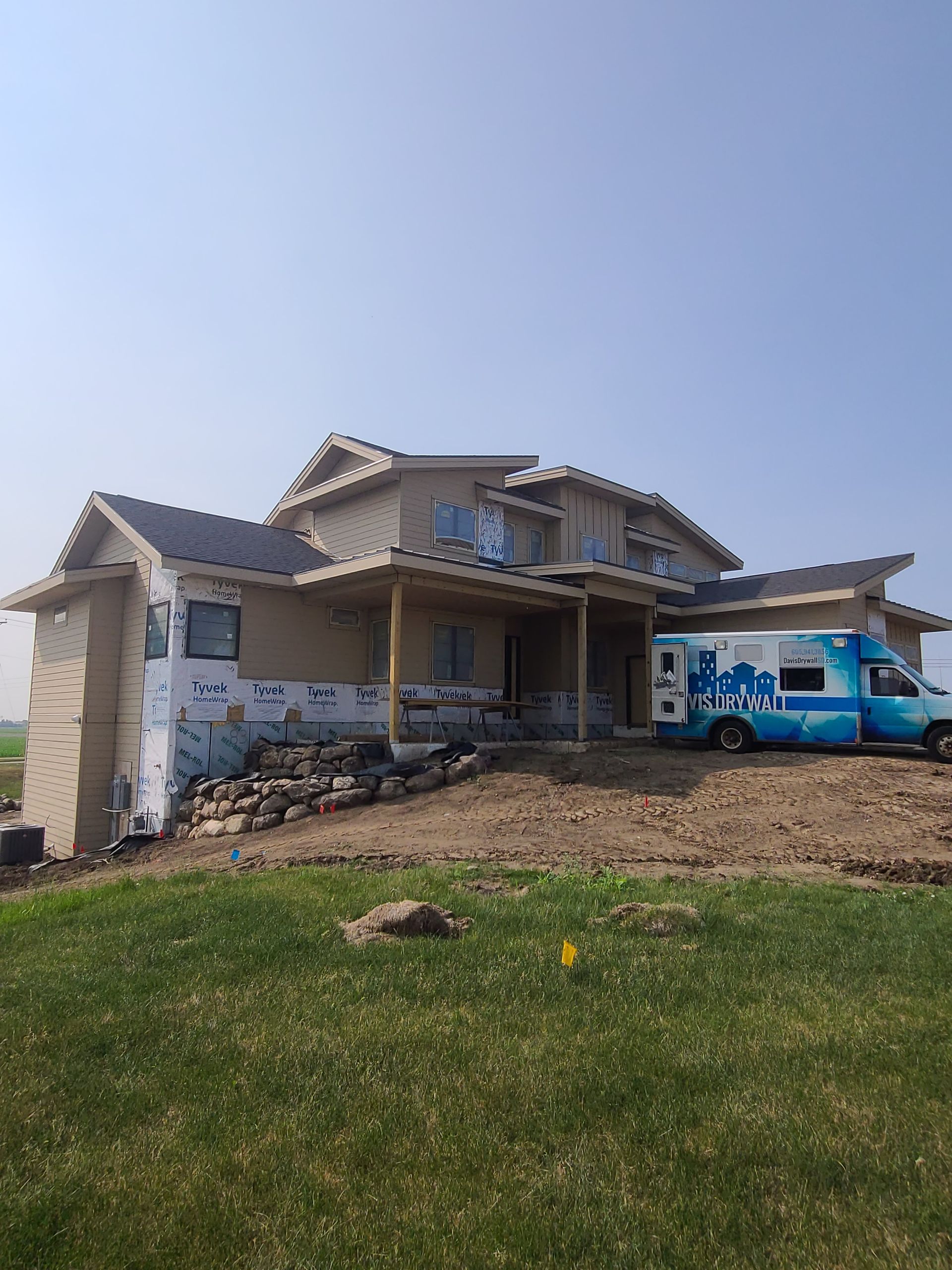 House under construction with blue service van parked outside.