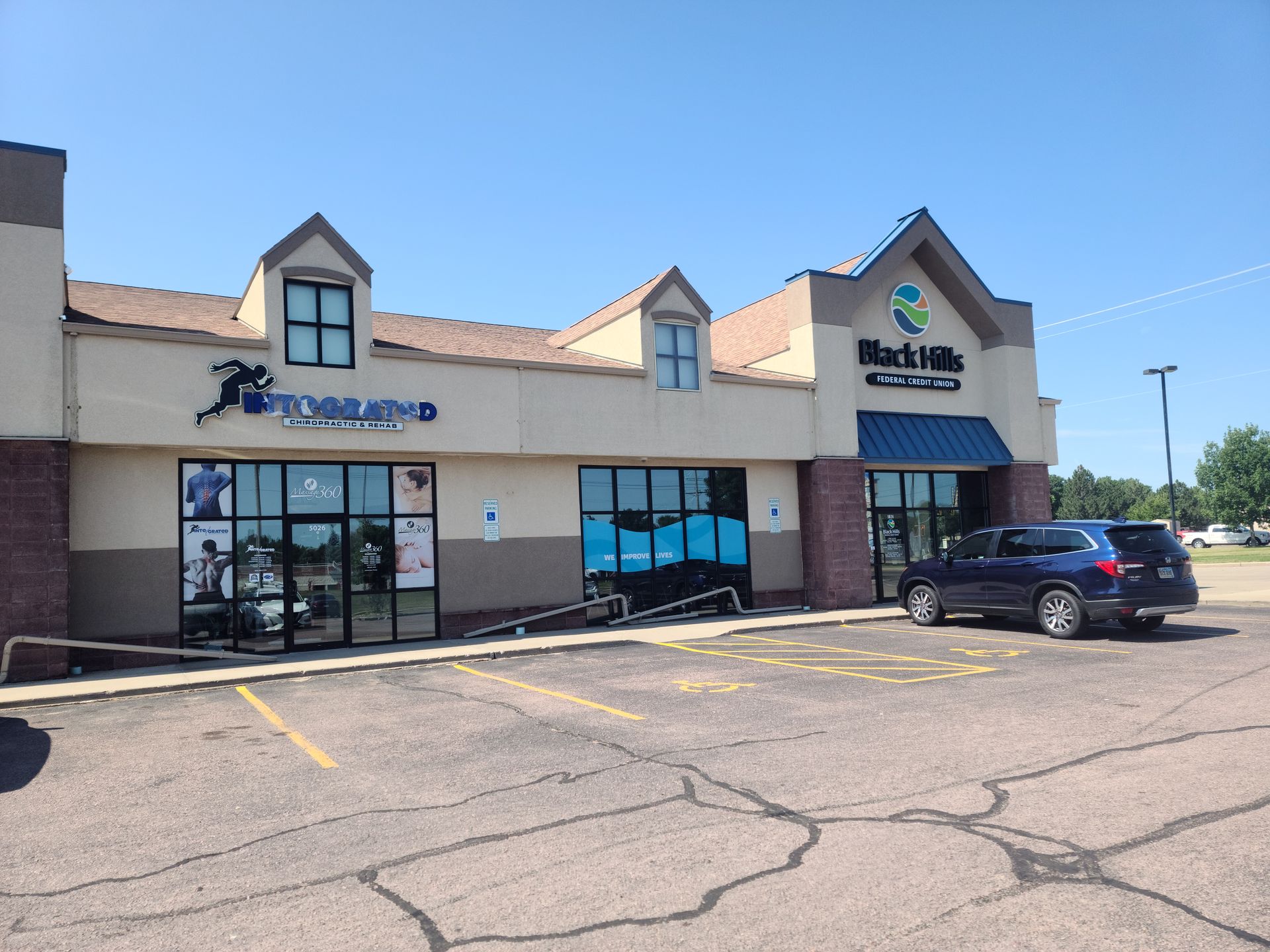 Exterior of two businesses in a strip mall. 