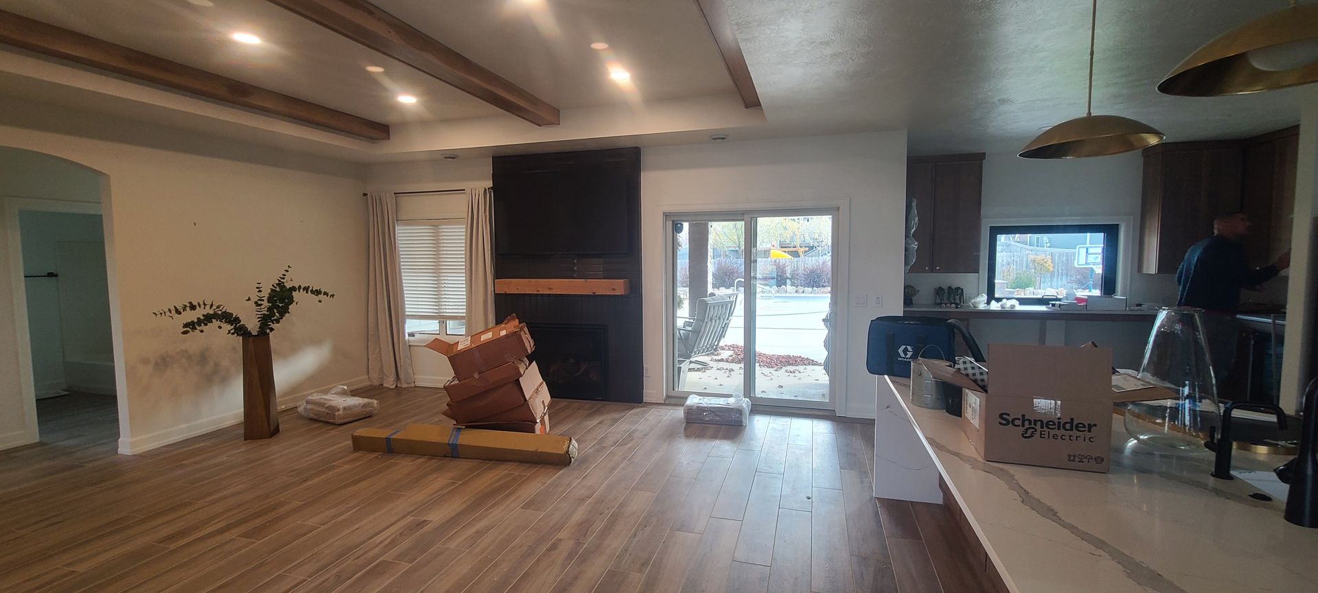 Interior view of a living room with wooden floors, fireplace, and sliding glass door.