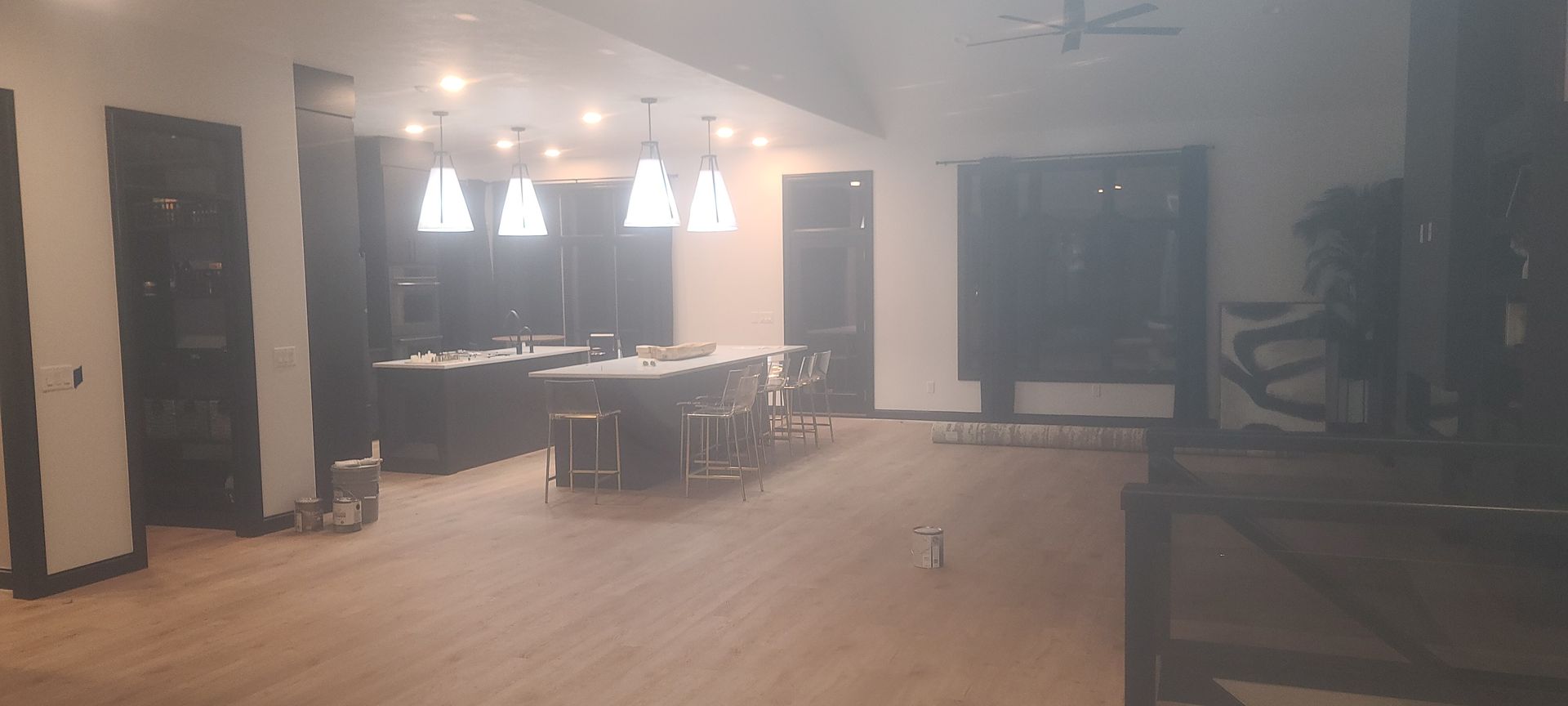 Spacious, bright interior with kitchen island, pendant lights, and hardwood floors.