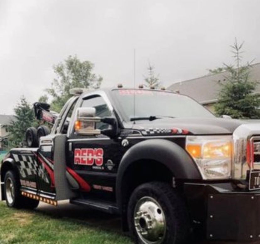 A red 's red 's tow truck is parked in the grass