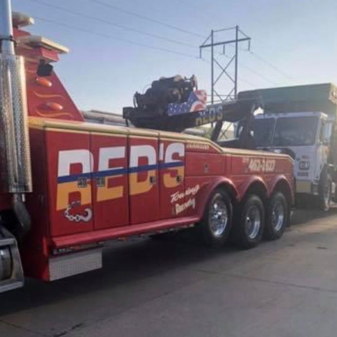 A red 's tow truck is parked on the side of the road