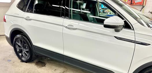 White SUV with black accents parked indoors.