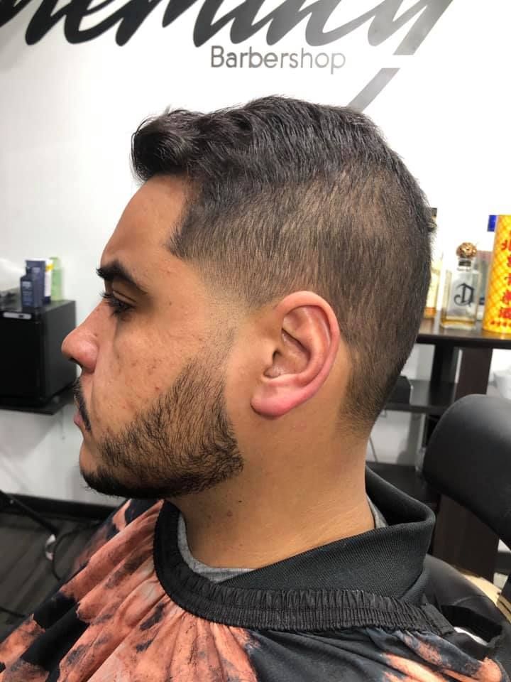 A man is getting his hair cut at a barber shop