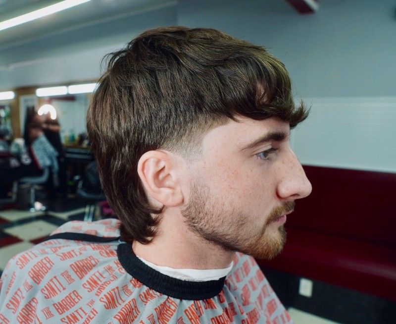 A man is getting his hair cut at a barber shop