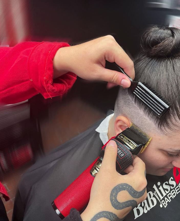 A person is getting their hair cut by a babyliss barber