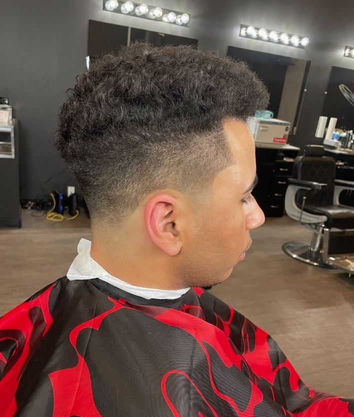 A man is getting his hair cut at a barber shop.