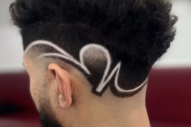 The back of a man 's head with a design on it.