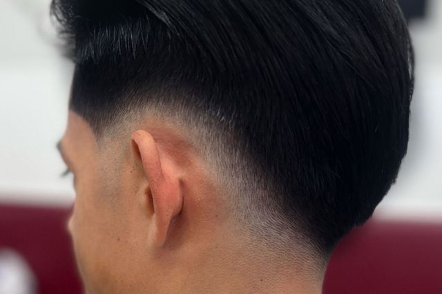 The back of a man 's head with a very short haircut.