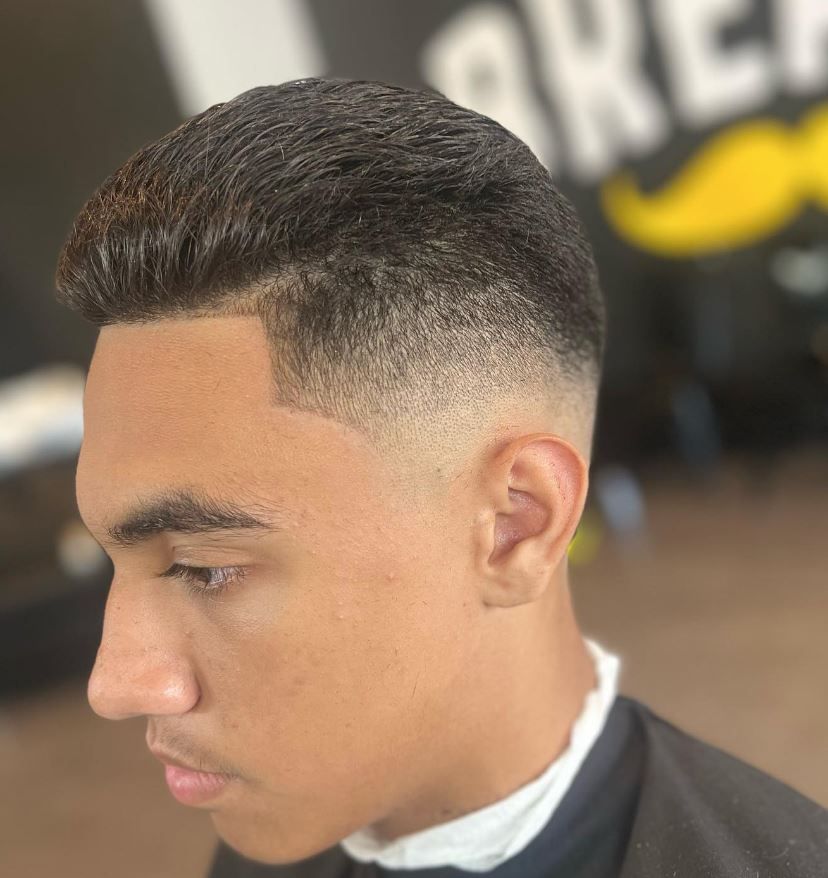 A man is getting his hair cut at a barber shop