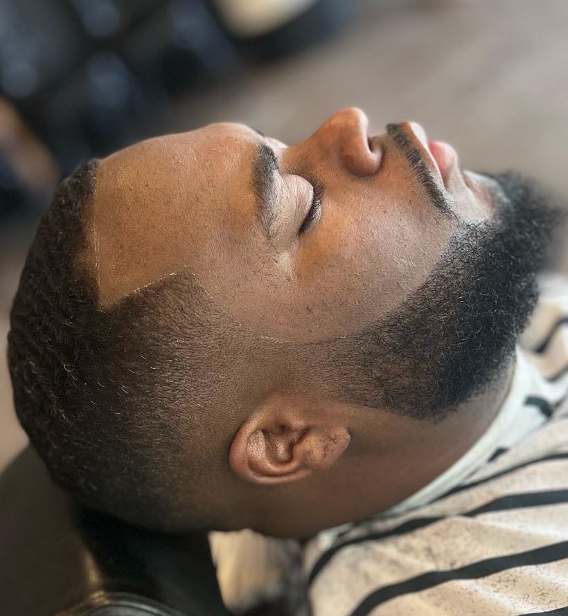 A man with a beard is laying down with his eyes closed