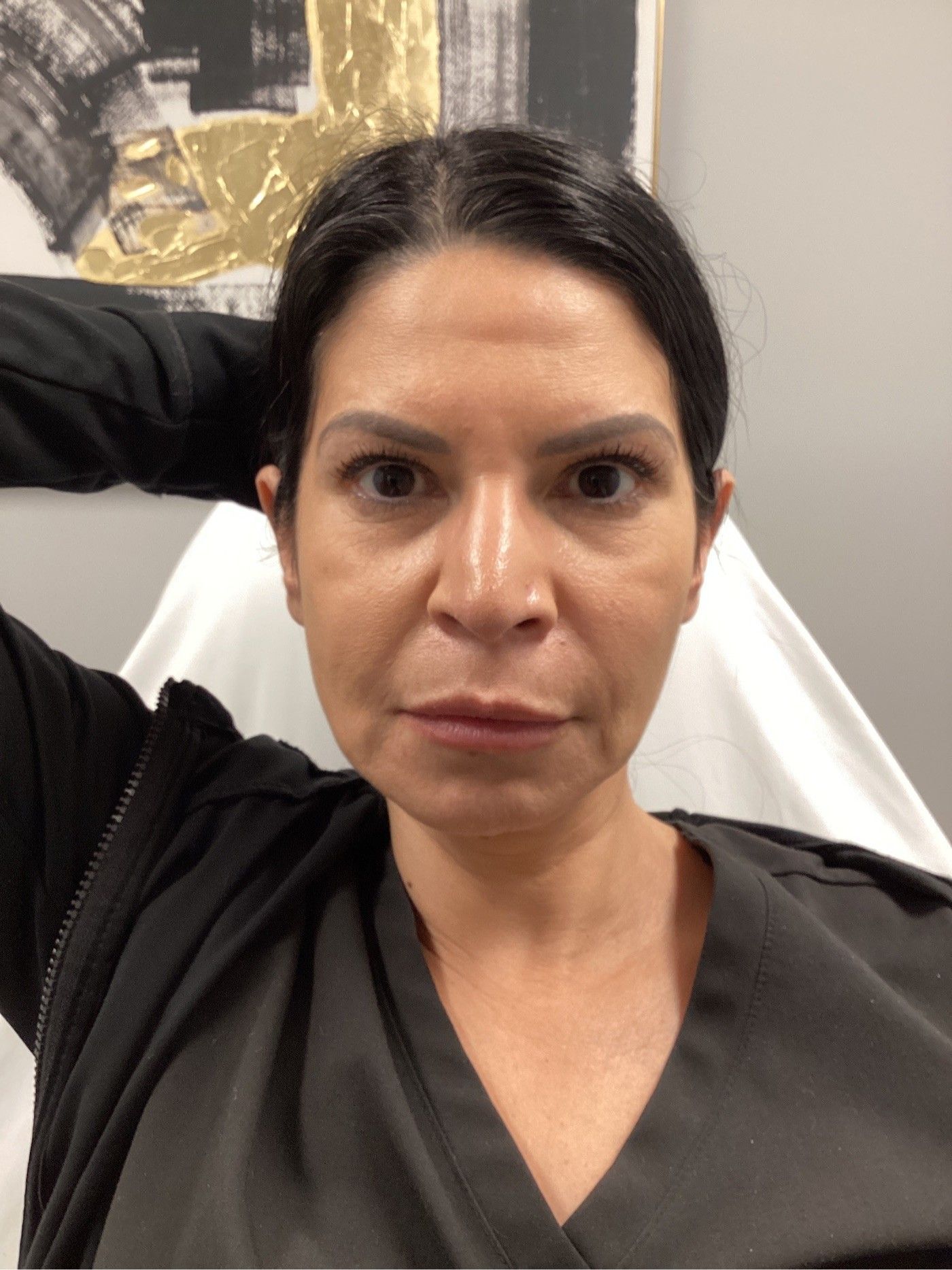 Woman with dark hair looking at the camera, wearing black clothing. Neutral expression, indoor setting.