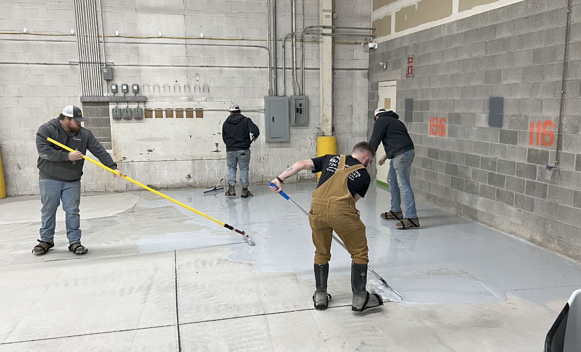 A group of men are cleaning the floor of a building.