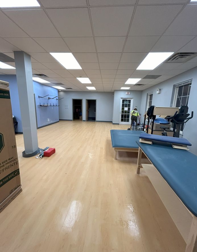A large empty room with wooden floors and a blue table.