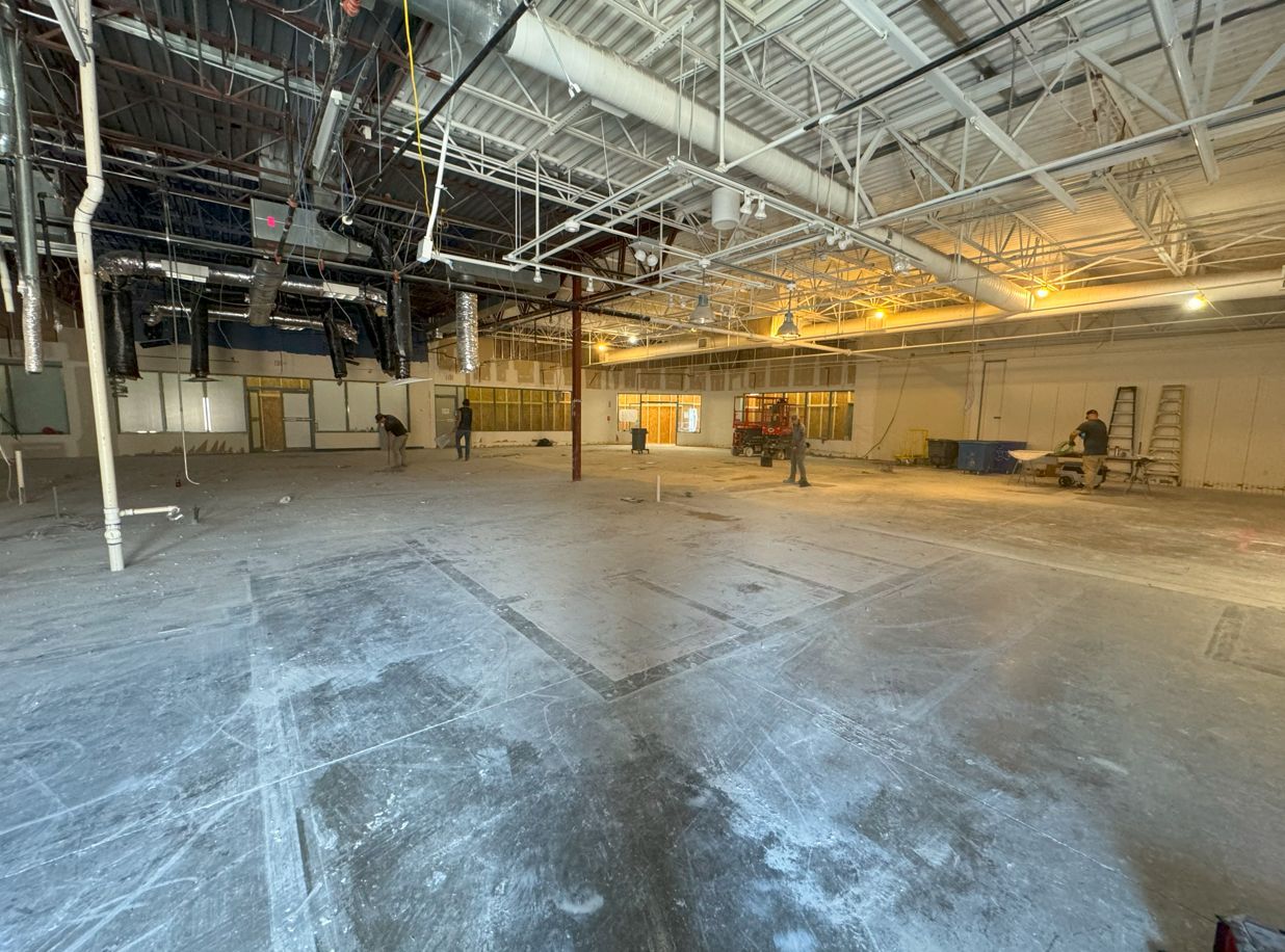 A large empty building with a lot of pipes hanging from the ceiling.