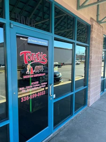 Exterior of Toreros Mexican Restaurant with blue trim, glass windows, and door.