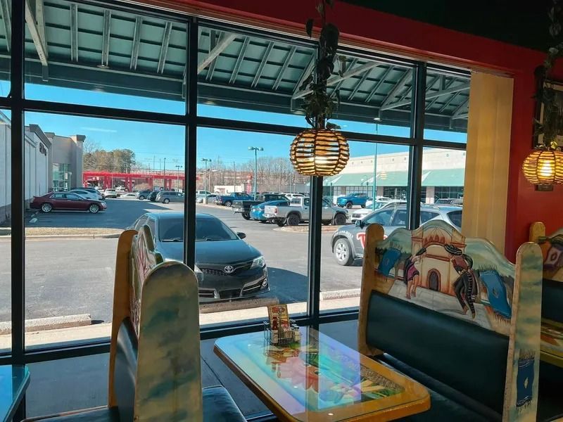 Inside a Mexican restaurant, a booth with a view of a parking lot on a sunny day.