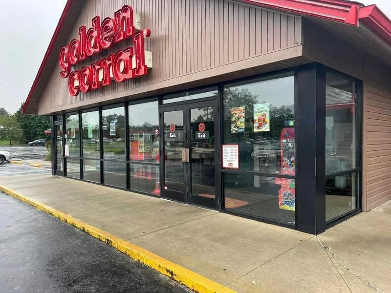 Exterior of a Golden Central convenience store with glass front, red sign on beige building, gray sidewalk.