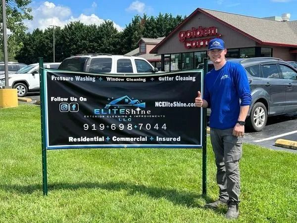 Man in blue shirt stands next to a sign for EliteShine window cleaning business.