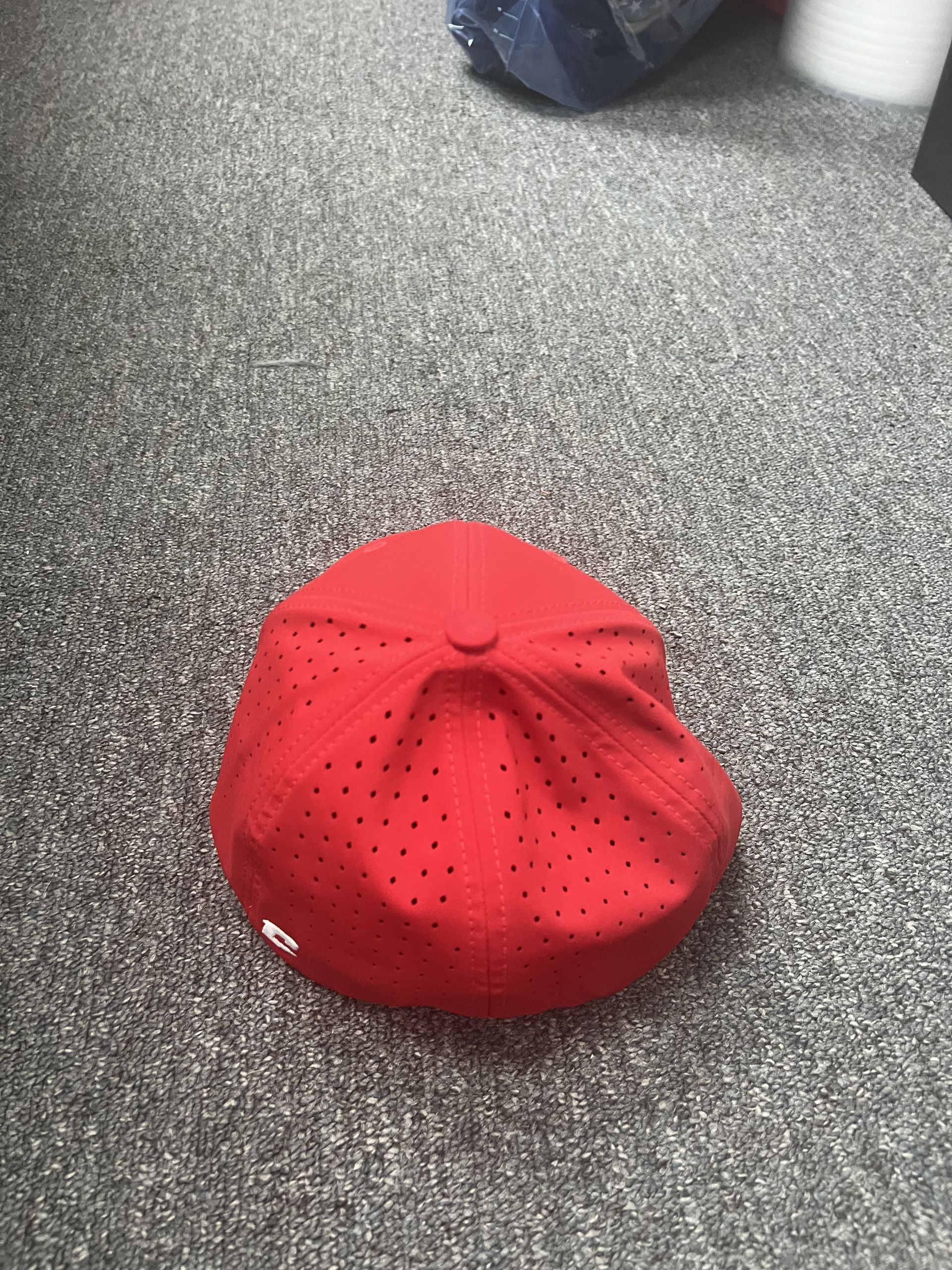 Red cap with a dotted pattern sitting on a gray carpet.