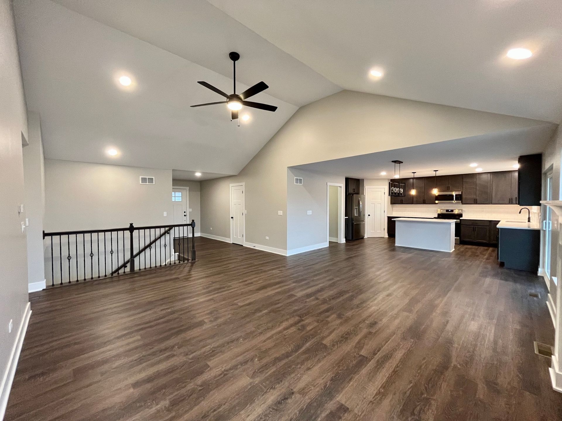 A living room with hardwood floors and a ceiling fan.