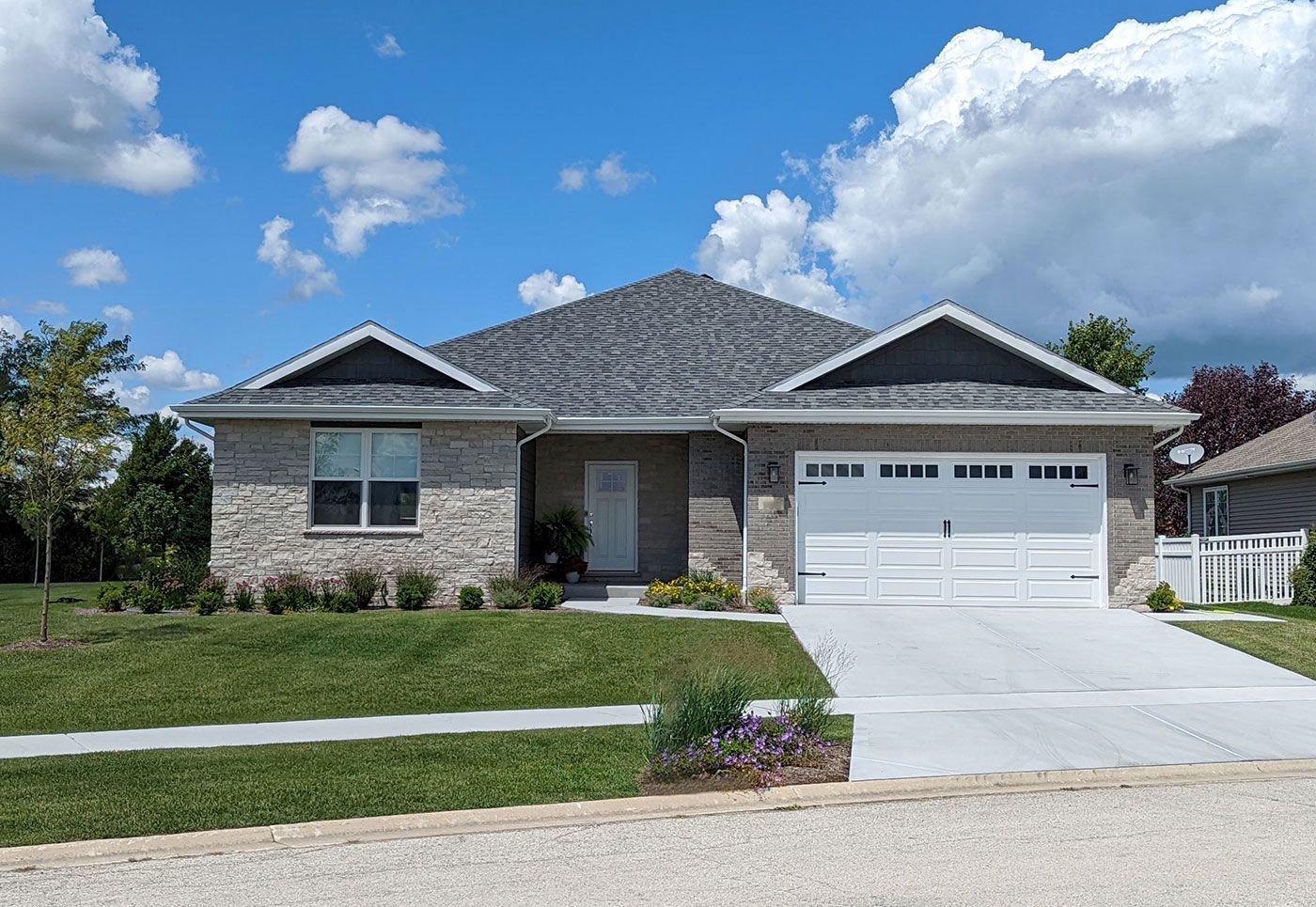 A large house with a gray roof and a white garage door.